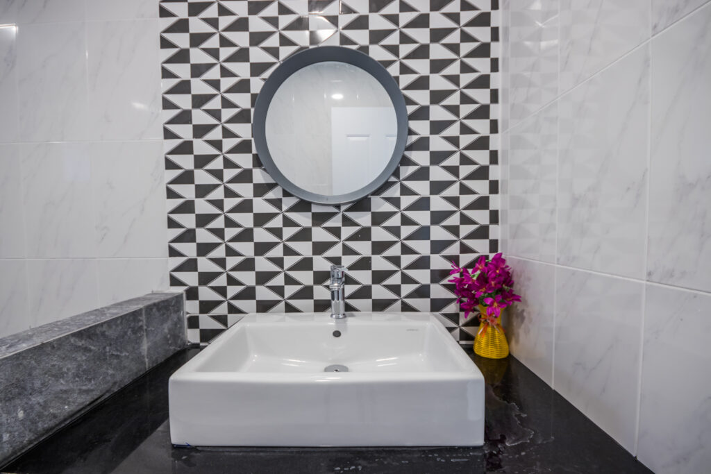 Close-up small basin in  bathroom, White and black ceramic wall