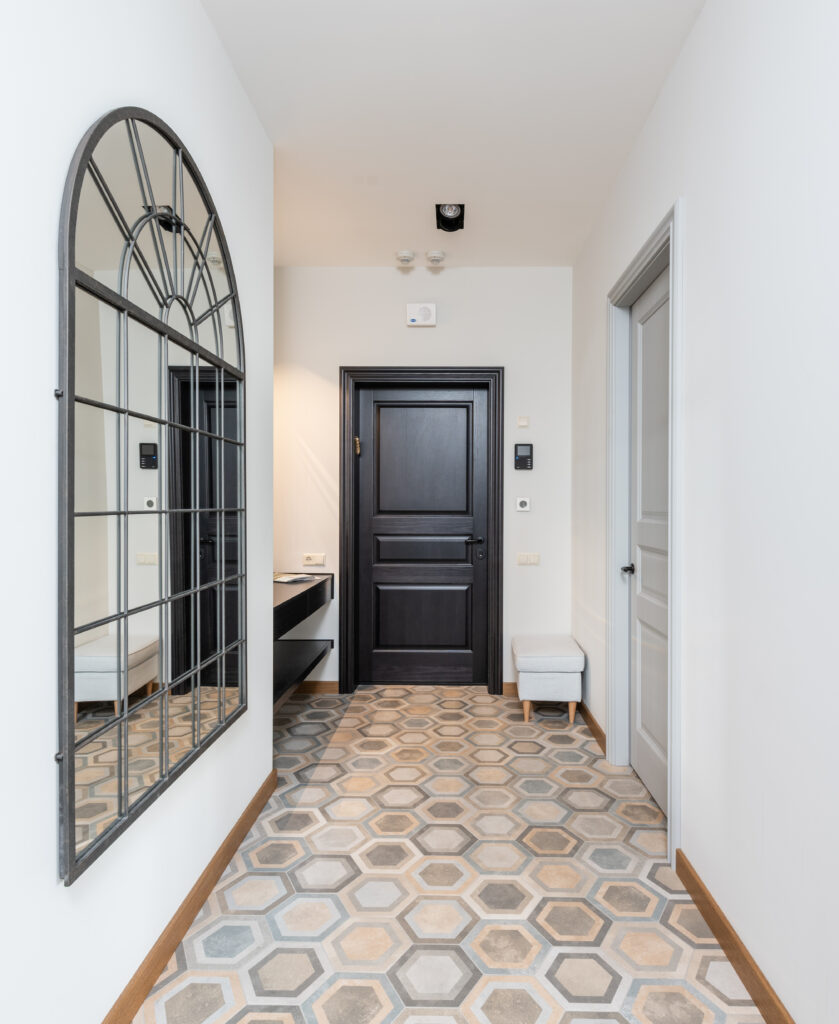 Empty corridor with light walls and decorative mirror in apartment