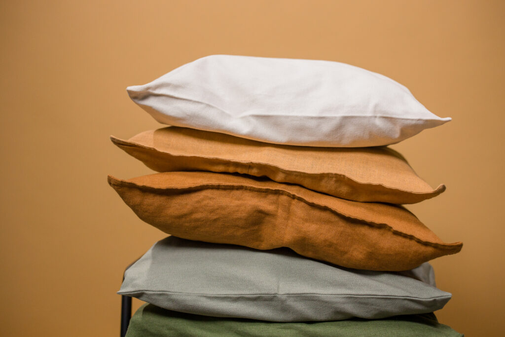 Stack of colorful pillows isolated on beige background