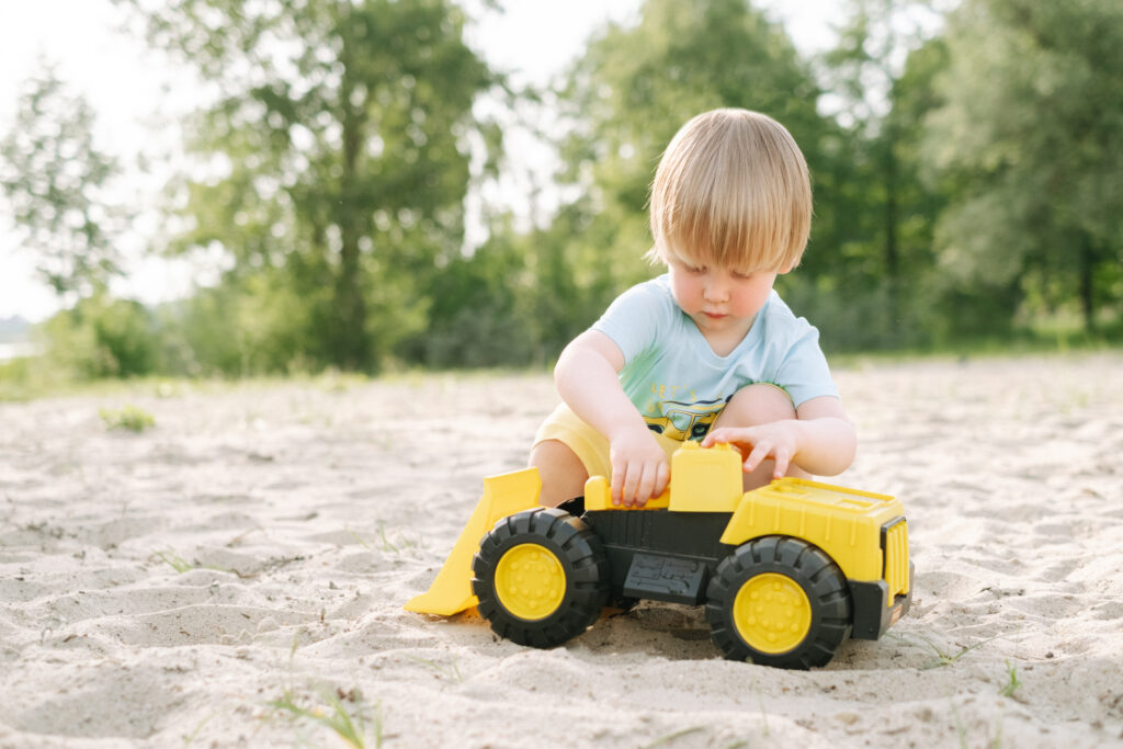 A boy playing with a toy truck