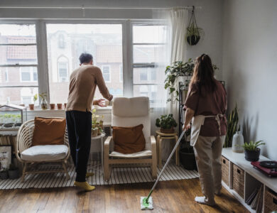 A couple cleaning the living room