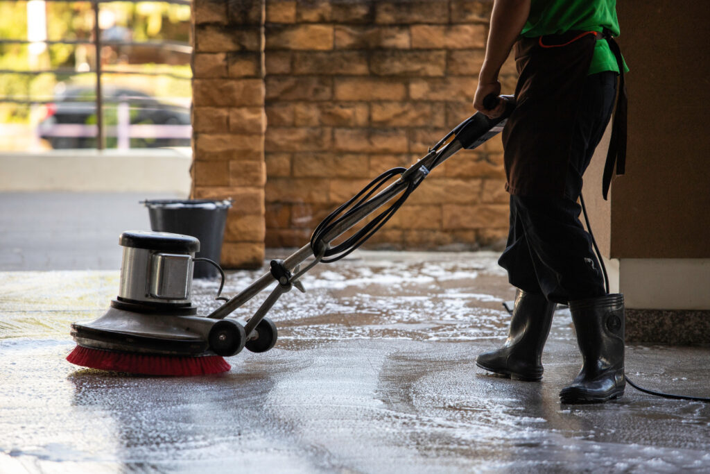 A man worker cleaning the floor with polishing machine