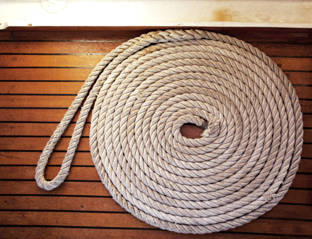 A rope coil laid across teak decking.