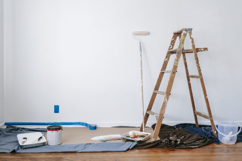 Brown wooden ladder beside painting materials