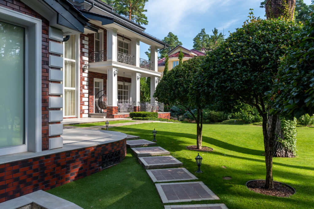 Cottage exterior near plants with trees and pathway in yard