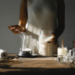Crop black woman pouring wax into beaker