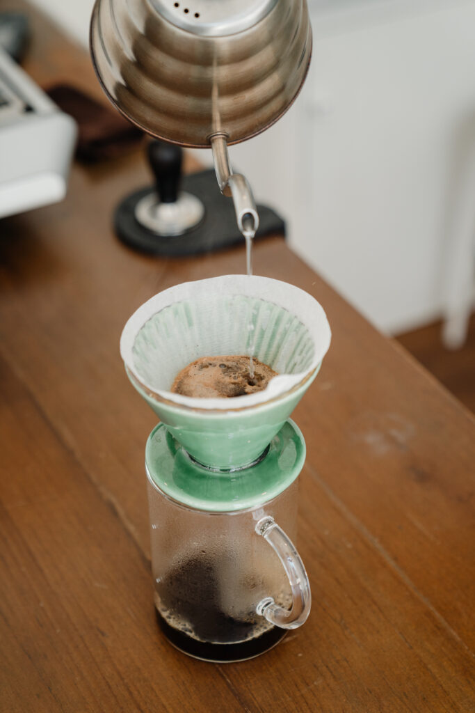 Hot water pouring from kettle into pourover filter