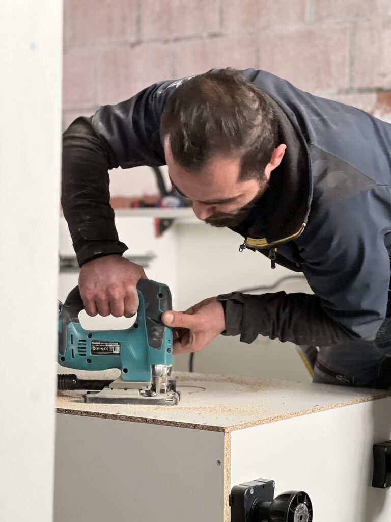 Man standing and cutting furniture