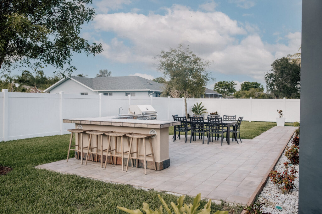 Outdoor patio with grill, bar, and dining table