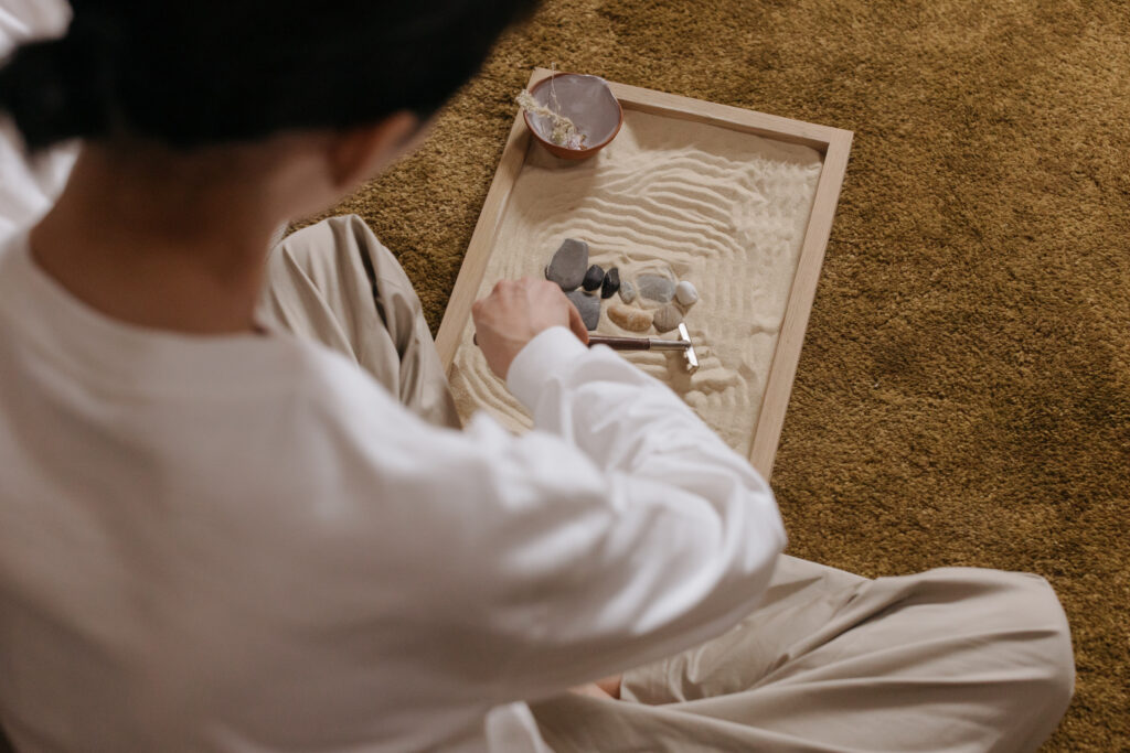 Overhead shot of a person using a mini zen garden