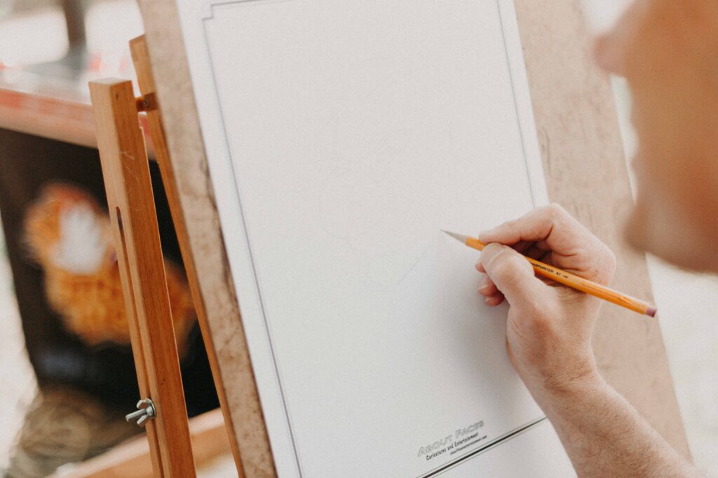 Person holding pencil on white canvas