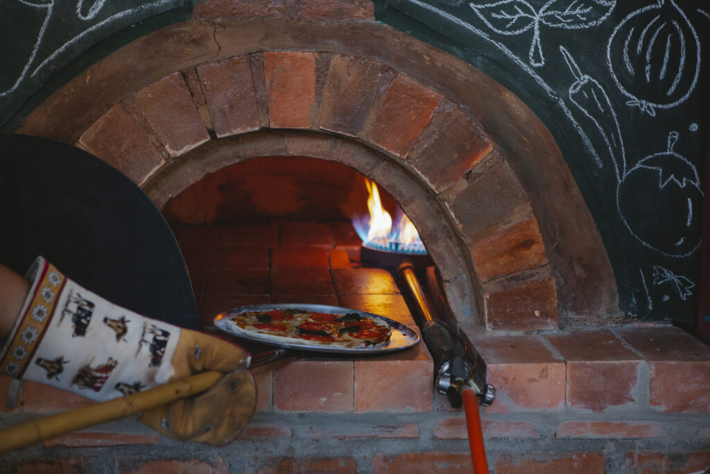 Pizzerman putting a pizza in the oven