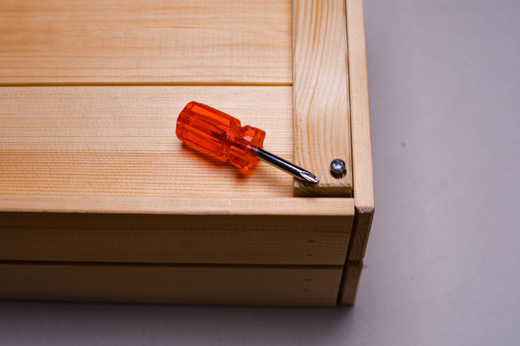 Red and silver screwdriver on wooden surface