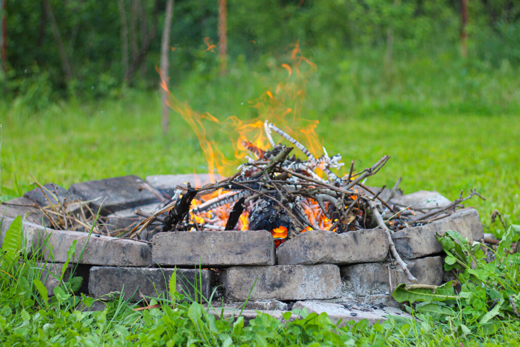 Refractory brick campfire in focus and blurred bonfire green grass in the background