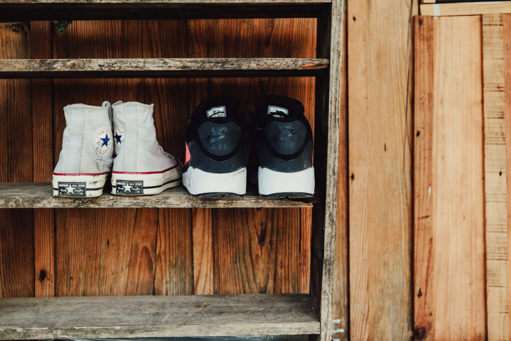 Two pairs of gray and black sneakers on rack