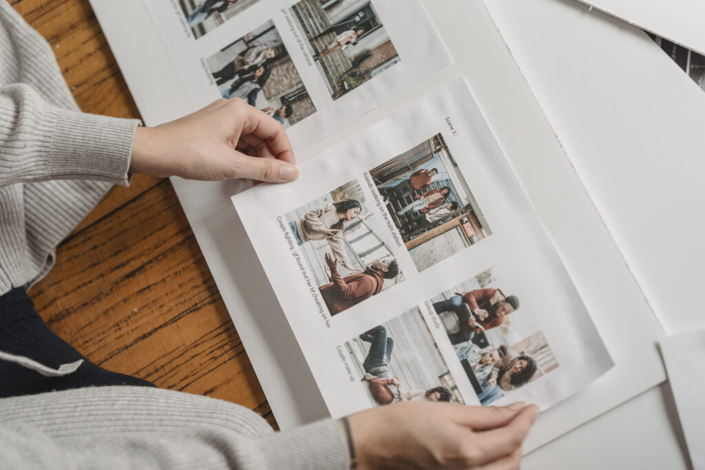 Unrecognizable person pasting photos in family album