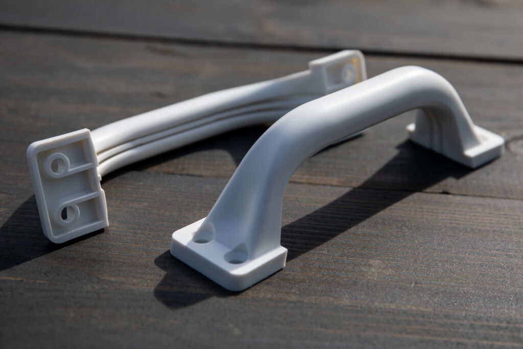 White plastic gate handles on a wooden texture background