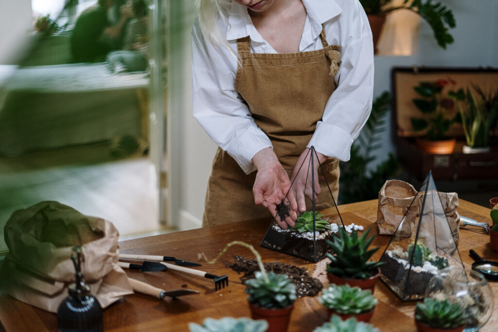 Woman in white apron holding green vegetable