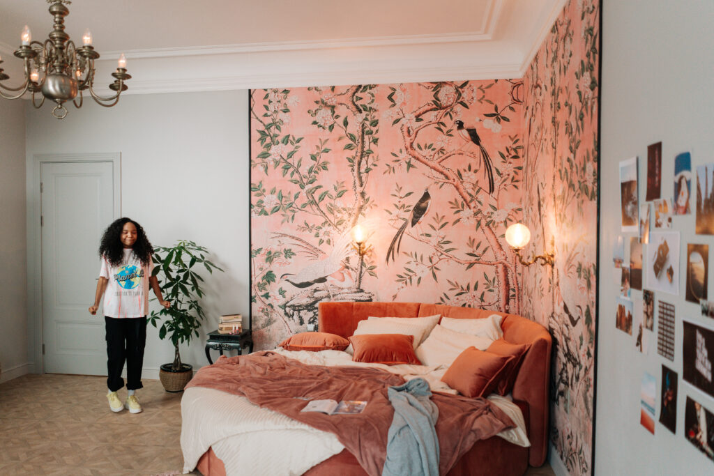 A girl with curly hair standing in the bedroom