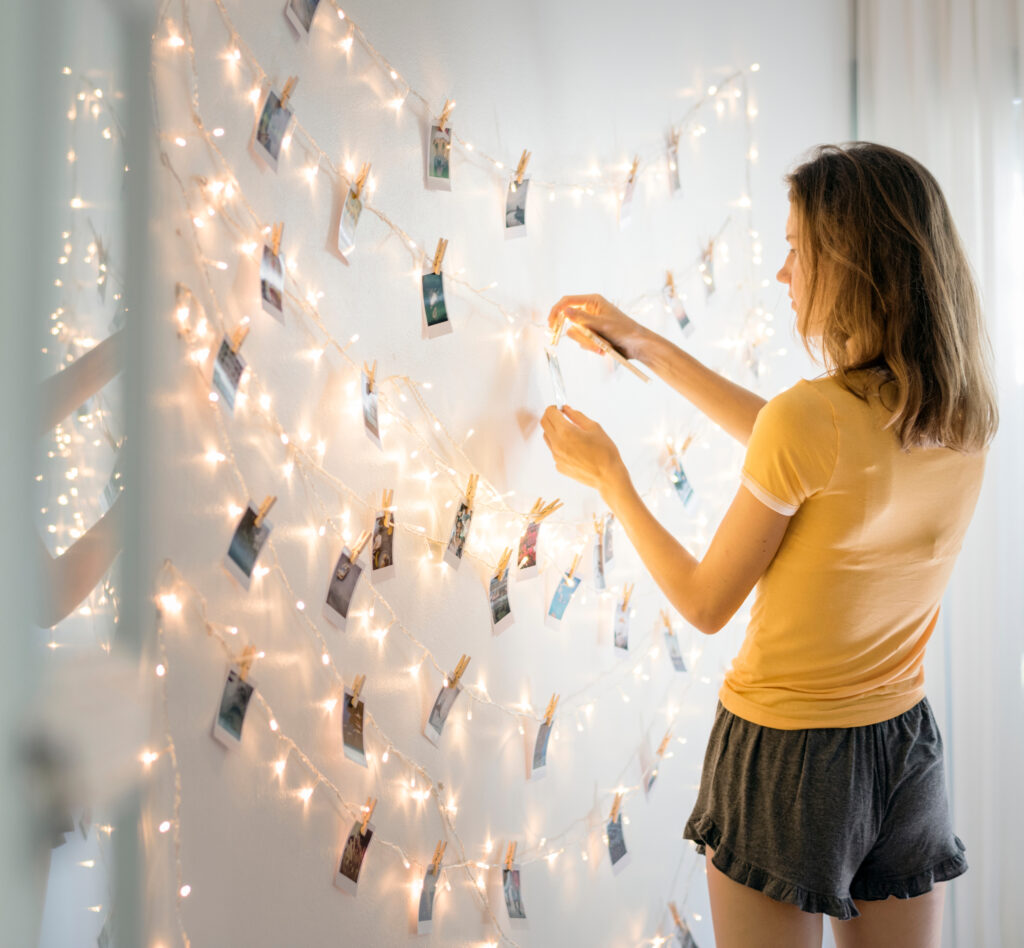 A woman looking at photos hanging on decoration lights