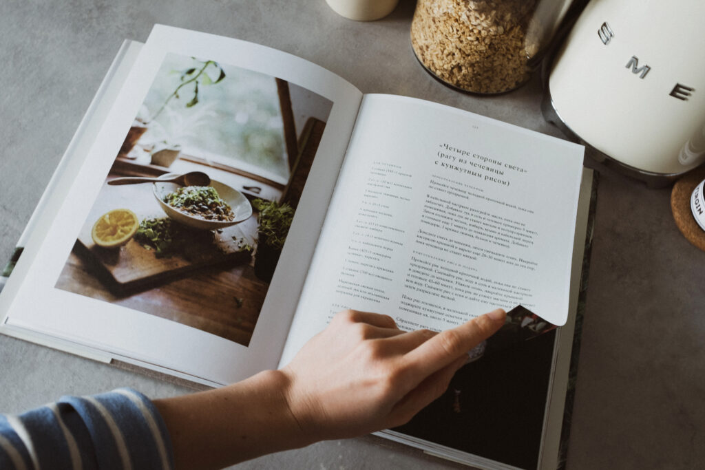 Anonymous housewife paging cookbook in kitchen