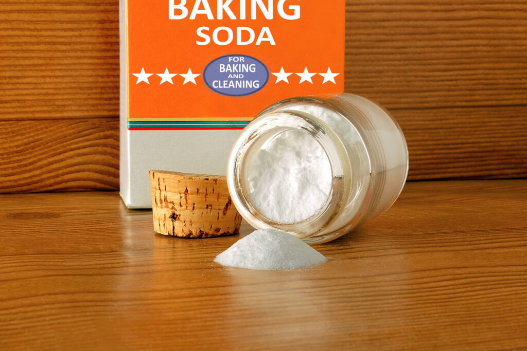 baking soda or baking powder in bottle isolated in wooden background for cooking recipe or cleaning