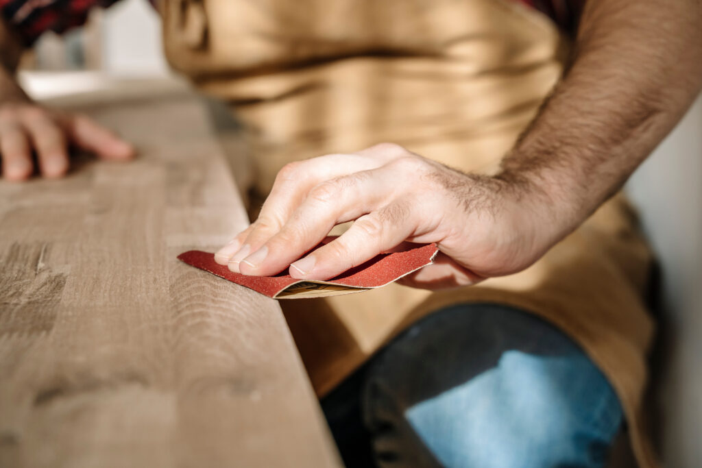 Carpenter works with wood in the workshop. Small business, production, craft concept.