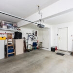 Clean organized suburban residential two car garage with tools, file cabinets and sports equipment.