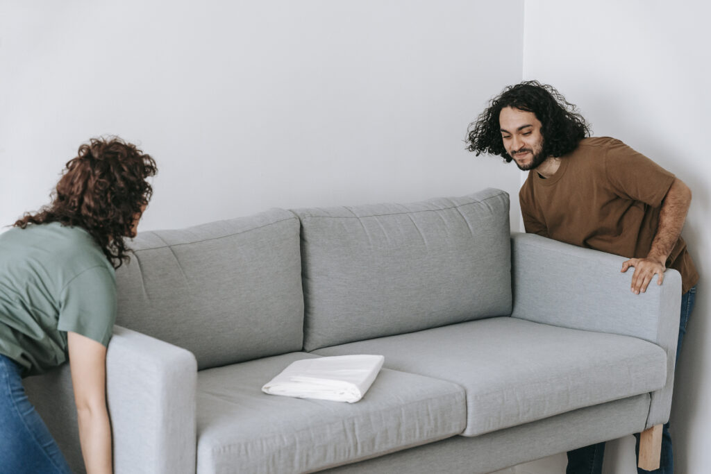 Couple moving sofa in room