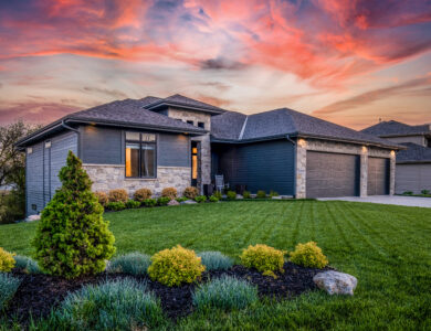 Luxury home during twilight golden hour with pink and purple sky and lush landscaping in Nebraska USA