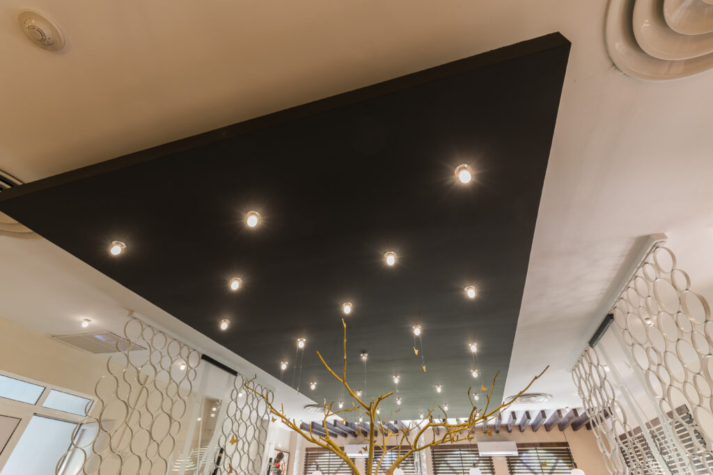 Nice amazing closeup view of interior stylish modern electrical ceiling lights on black panel