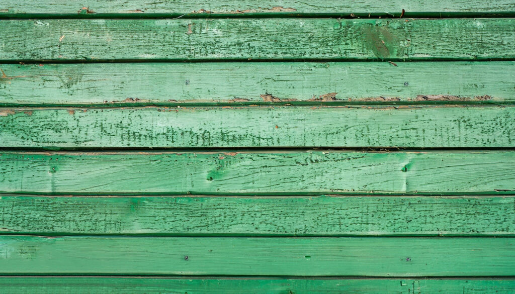 Old wooden fence with green paint background texture.