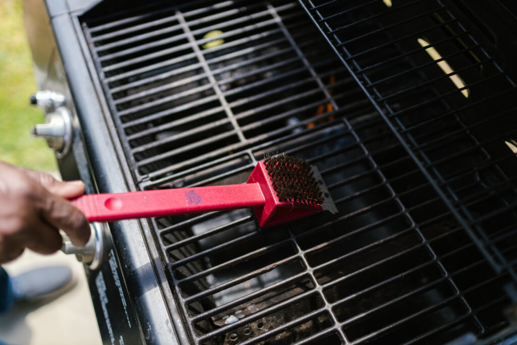 Person brushing the griller