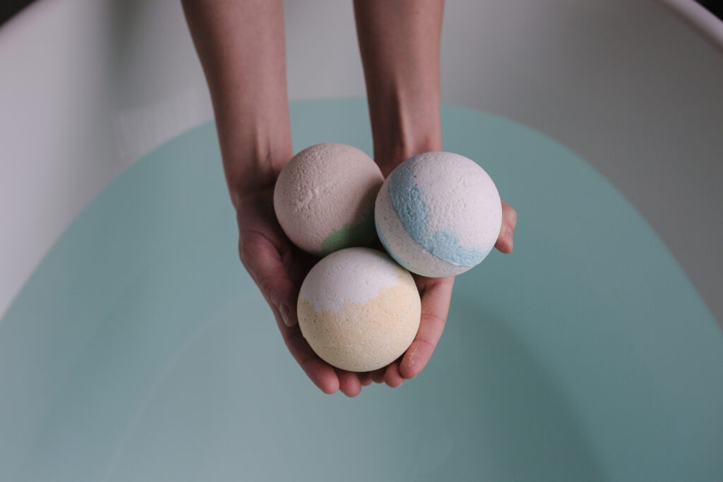 Person holding three bath balls