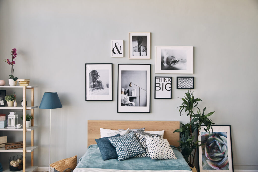 photos of different sizes in a frame hanging over the bed . Modern bedroom interior.