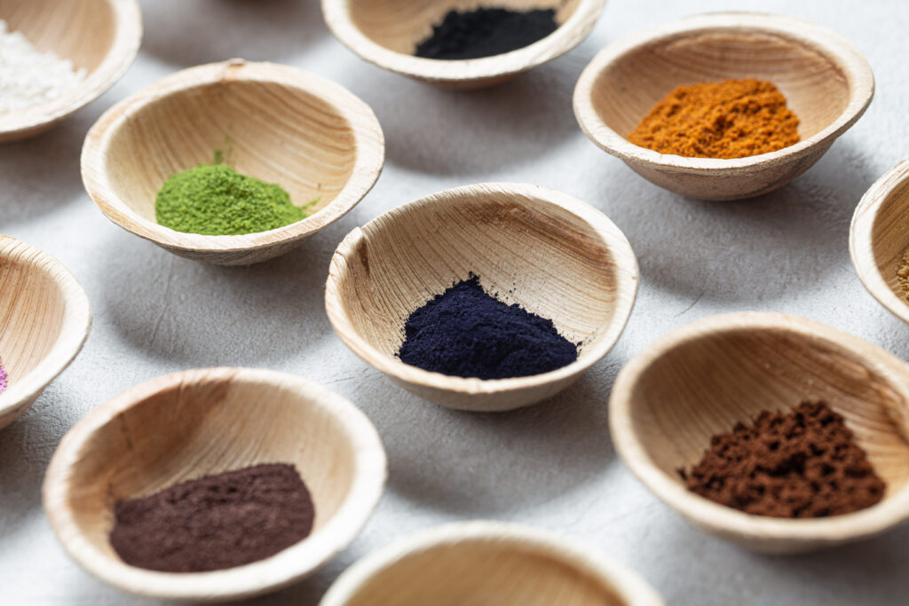 Set of natural pigment powder from herbs in small bowls. Dye from nature.