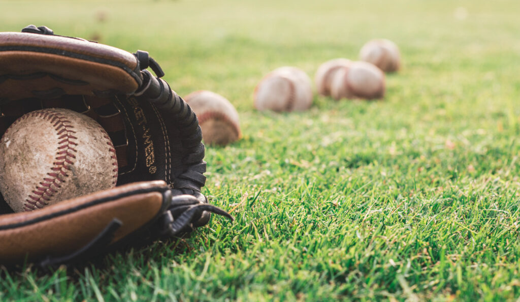 White baseball ball on brown leather baseball mitt