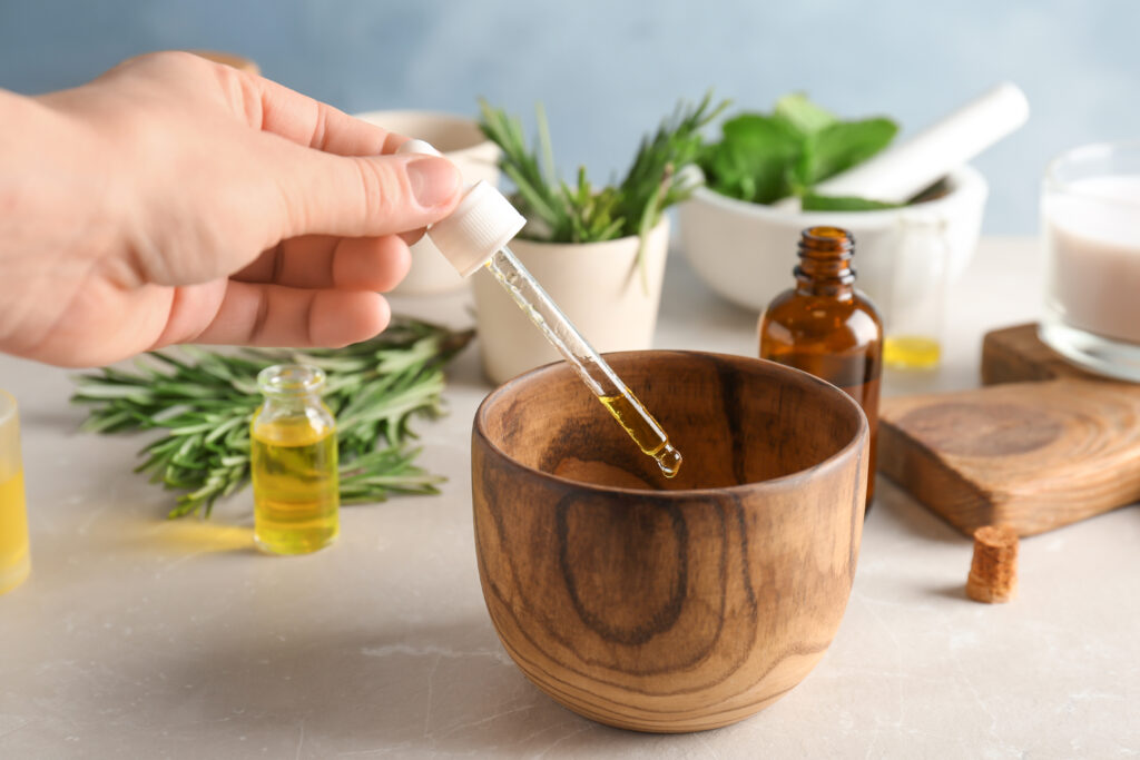 Woman dropping essential oil into bowl