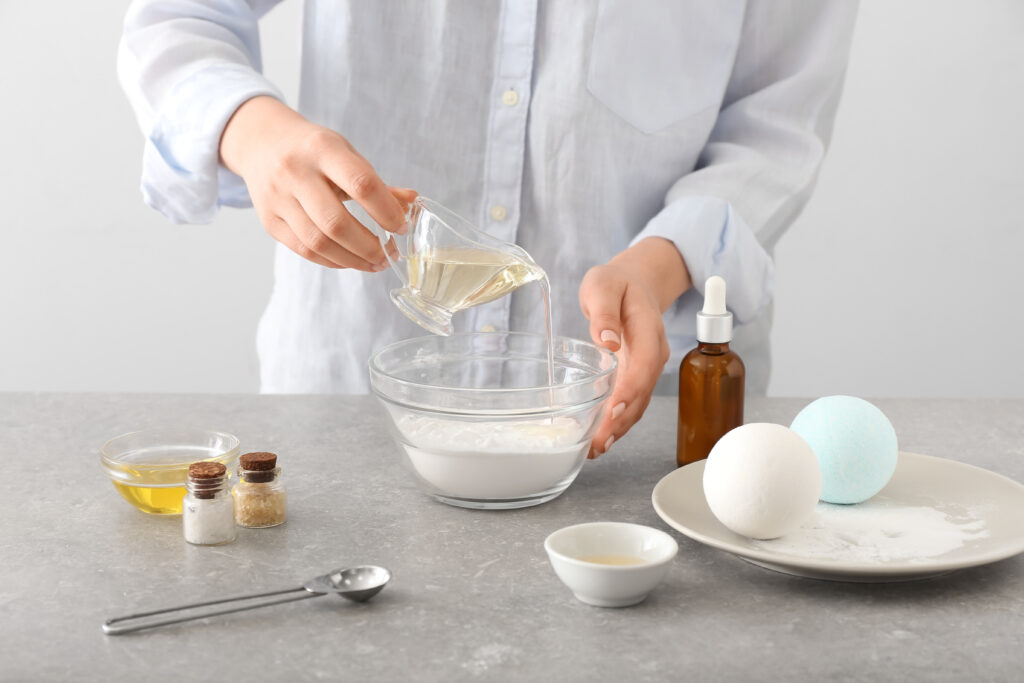 Woman making natural cosmetic on light background