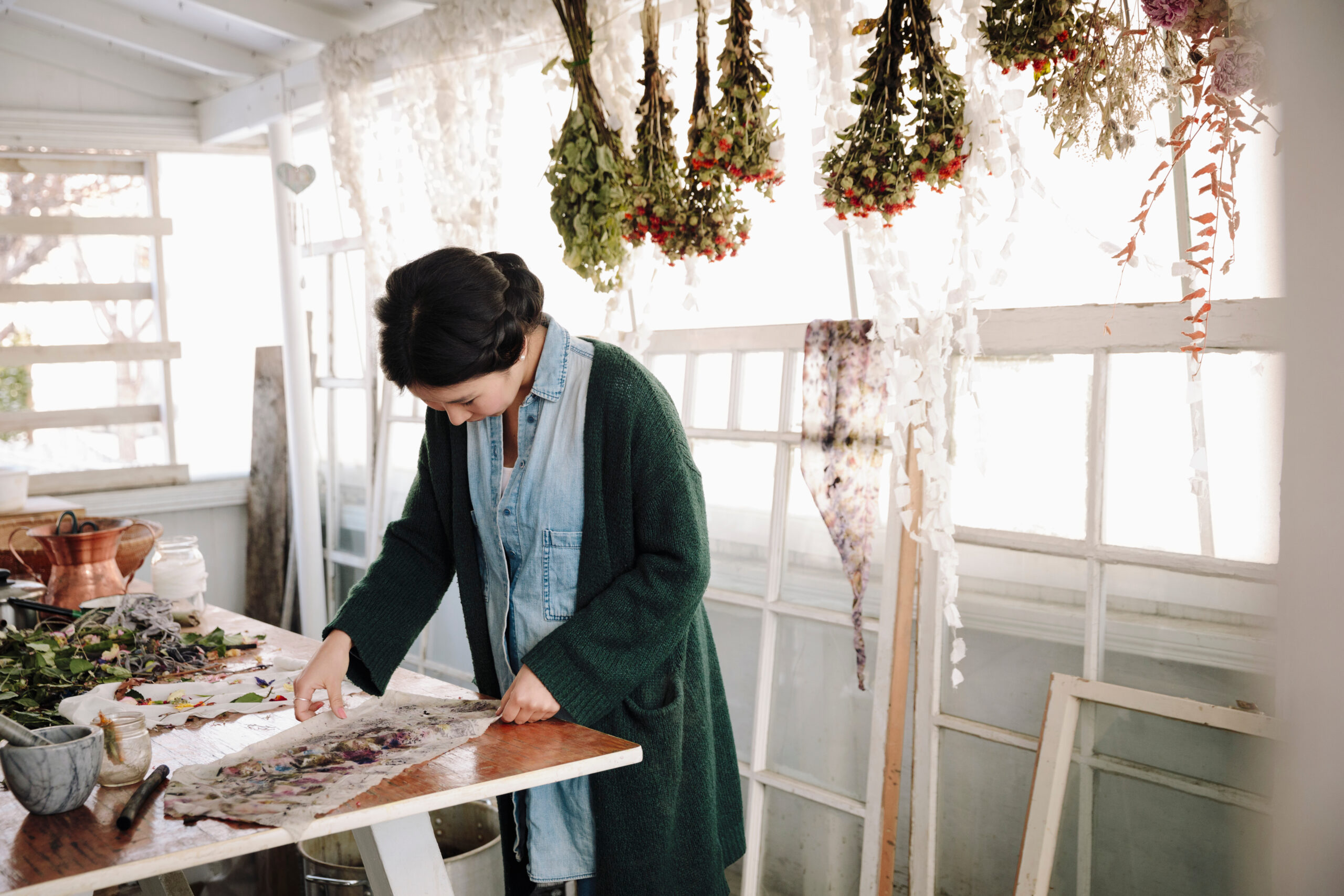 Woman pressing dried flowers for paper making