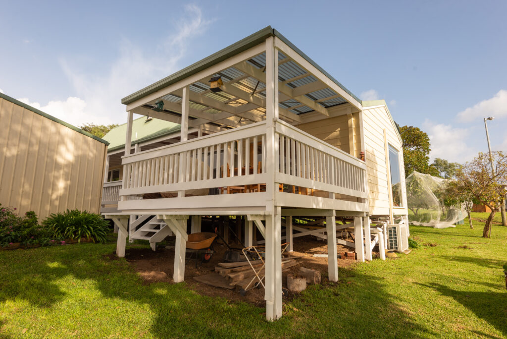 Decking above storage area with wheelbarrow and tools