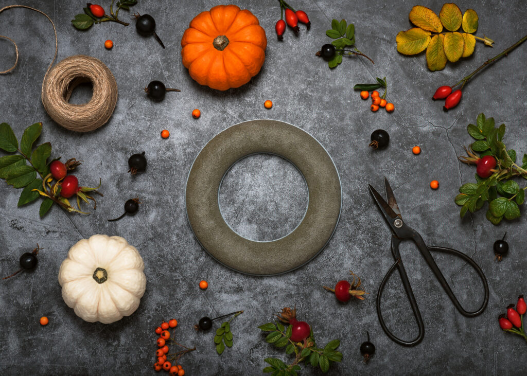 Making autumn wreath on dark florist table with professional foam ring and wild rose hips. Decorative home handmade concept. Step 1. Top view.