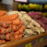 Piles of root vegetables lying on a food market stall
