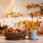 Autumn kitchen interior. Red and yellow leaves and flowers in the vase and pumpkin on light background