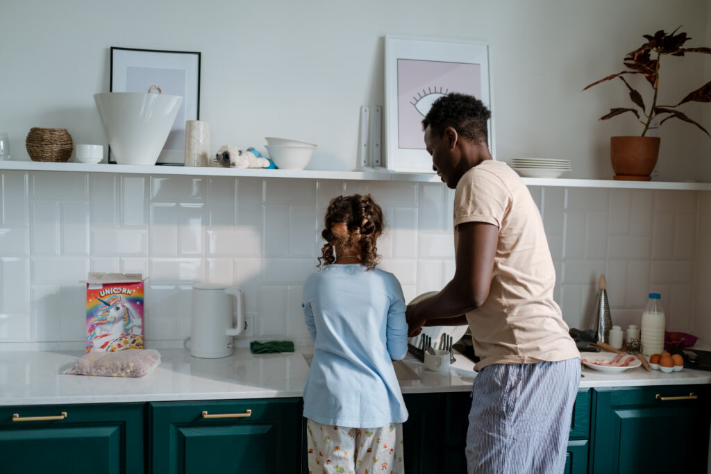 Girl and man standing beside kitchen counter top