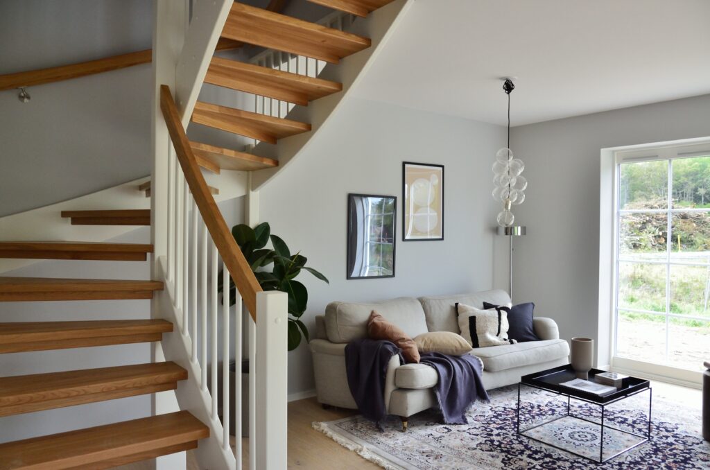 White sofa beside brown wooden staircase