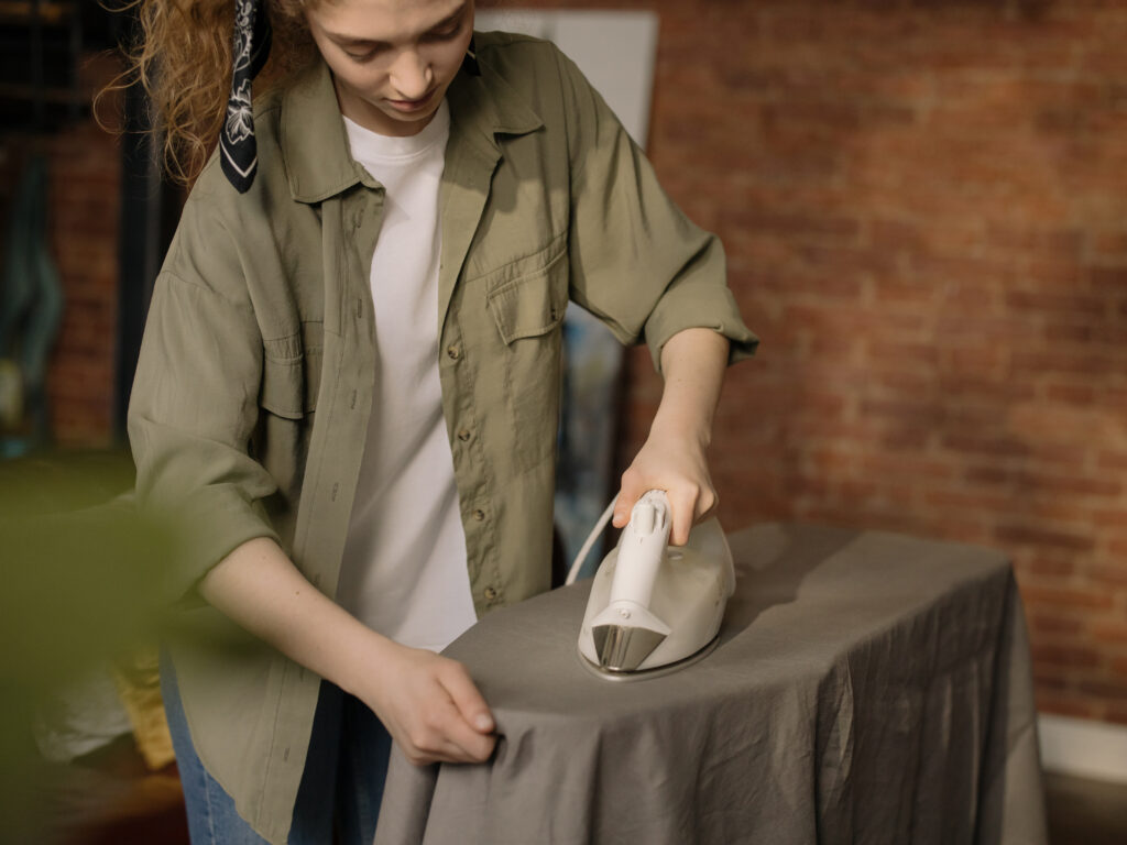 Woman in brown button up shirt holding white ceramic mug