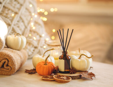 Cozy corner for home meditation and relaxation. Aroma diffuser, burning candles, pleasure and aromatherapy. Fall decor with pumpkins for apartment, house, indoors design. Thanksgiving decoration