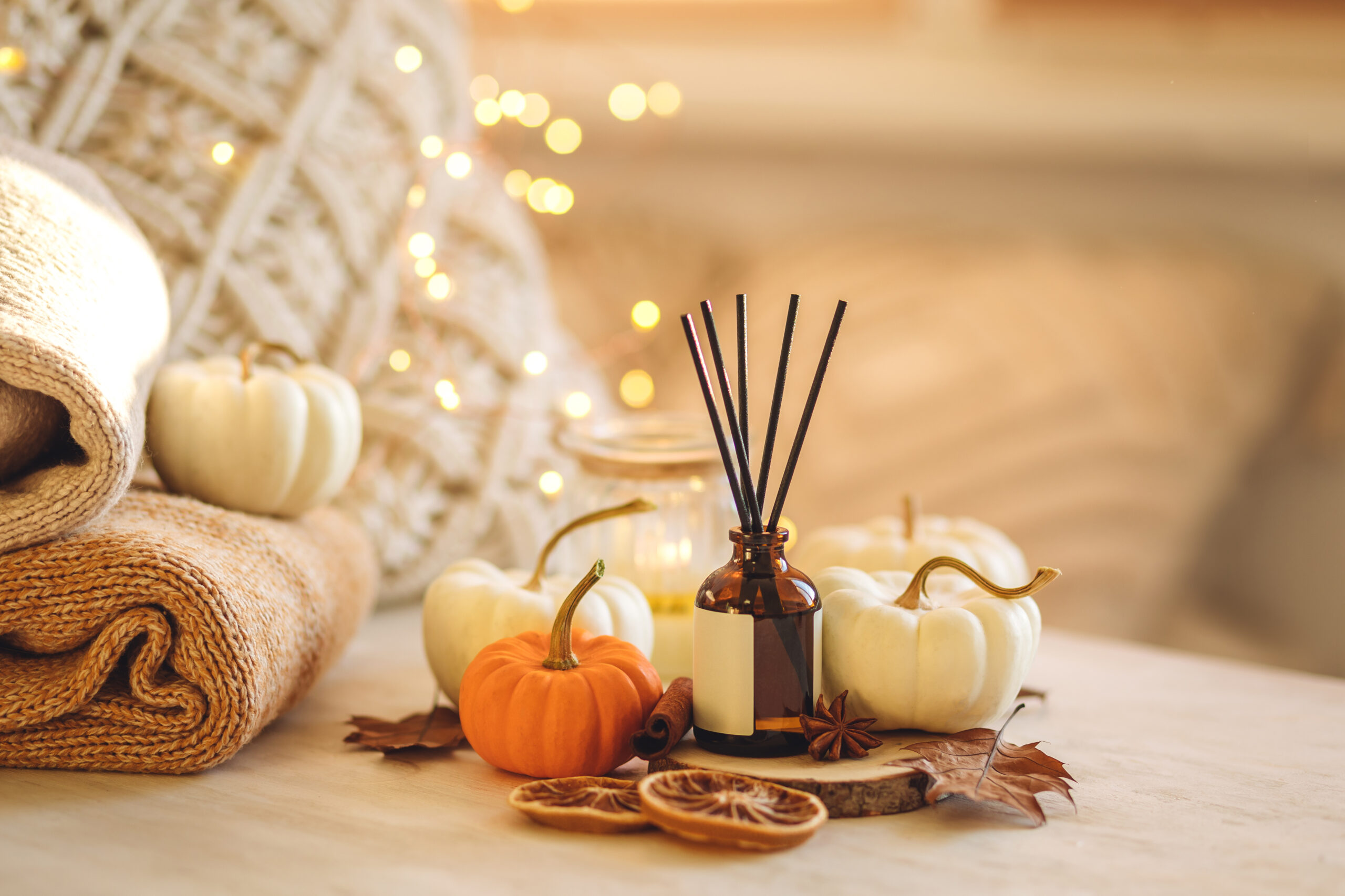 Cozy corner for home meditation and relaxation. Aroma diffuser, burning candles, pleasure and aromatherapy. Fall decor with pumpkins for apartment, house, indoors design. Thanksgiving decoration