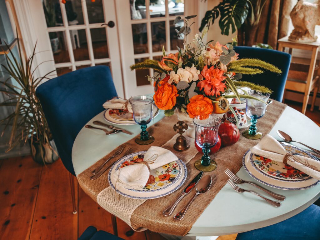 Dining room decorated for autumn / fall holidays.  Thanksgiving or autumn harvest with warm tones and velvet chairs.